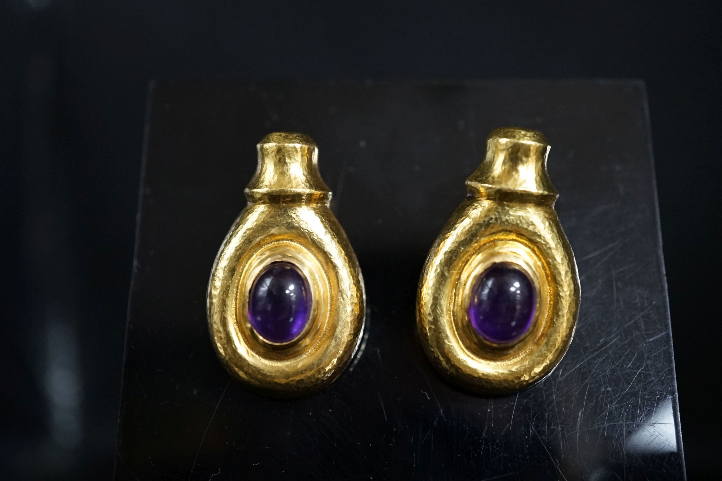 Attributed to Ilias Lalaounis, a pair of planished 750 yellow metal and cabochon amethyst set earrings, 30mm, 15.1 grams gross.